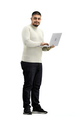A man, full-length, on a white background, uses a laptop
