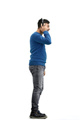 A man, full-length, on a white background, listening to music with headphones