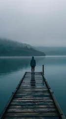 Muurstickers Solitude on the Lake: Reflective Water and Misty Horizon in Serene Scene Person standing at end of dock, misty lake, serene atmosphere, wooden pier, reflective water, foggy environment, solitude, cont © Matthew
