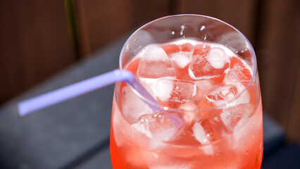 Fresh summer cocktail with strawberry juice and ice cubes. Glass of strawberry soda drink on dark background. Fresh strawberry cocktail.