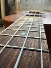 four strings ukulele guitar closeup on blurred background
