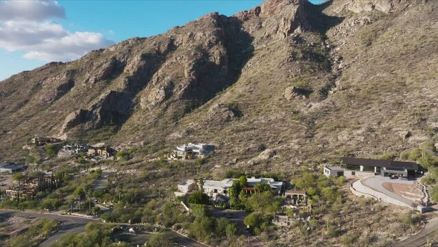 Drone Shot of Dramatic Mountains in Tucson Arizona with Upscale Estates Tucked into Foothills with Blue Skies in Background