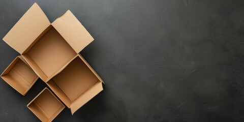 Empty open brown cardboard boxes on dark gray color background. Top view