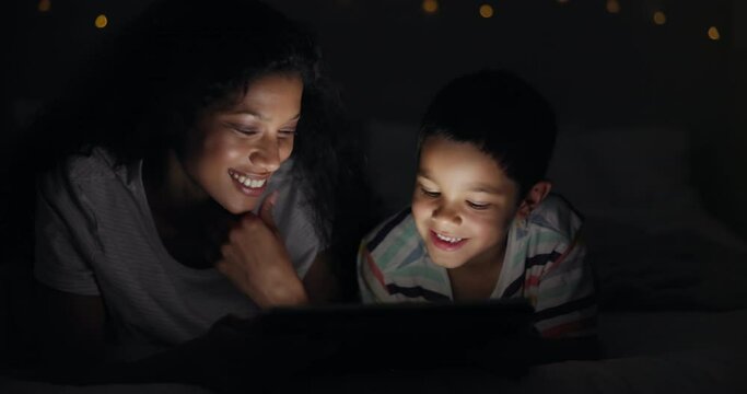Night, bedroom and mother with boy, tablet and smile with sleeping routine and connection with ebook. Family, mama and son with tech or dark with cartoon or bonding together with app, home or joyful