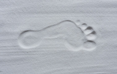 Footprint of human feet on the white sand