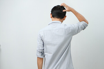 back view of asian indonesian man with hand grab his head showing stressful confused gesture....