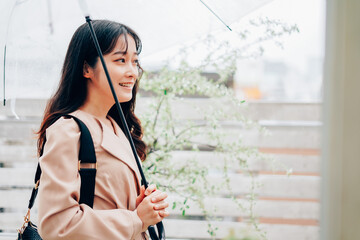 雨が降る中出勤する若い女性