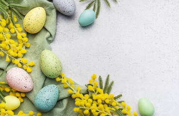 Colorful easter eggs  and mimosa flowers on concrete background.