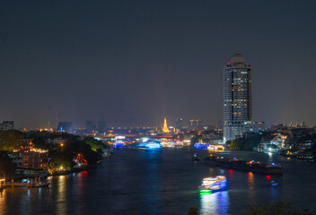 Fototapeta premium Aerial top view of Temple of Dawn or Wat Arun with urban city town in Rattanakosin Island in architecture, Urban old town city, Bangkok skyline. downtown area, Thailand.