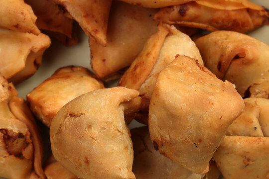Deep fried samosa singara stuffed with potato minced meat vegetable benglai snacks on enamel tin metal plate