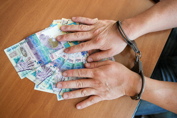 Concept of hands in handcuffs lie on the Kazakh tenge.
