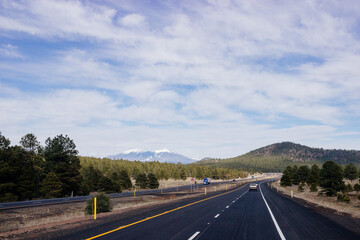 Beautiful blue sky with fluffy clouds over the highway. Scenic road in Arizona, USA on a sunny summer day. 40 hwy, 10 hwy in Arizona, USA - 17 April 2020