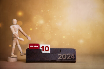 March's vibrant presentation: Wooden figure points to the tenth day on a bright calendar with warm-toned hues.