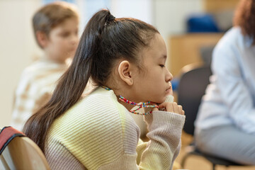 Side view portrait of Asian teenage girl with mental health problem in support group meeting for children