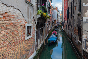 Small boat on a small canal street in Venice of beautiful colorful houses, Italy