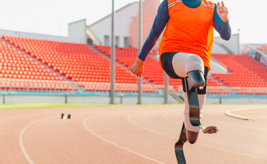 Naklejka premium Asian para-athlete runner prosthetic leg on the track alone outside on a stadium track Paralympic running concept.