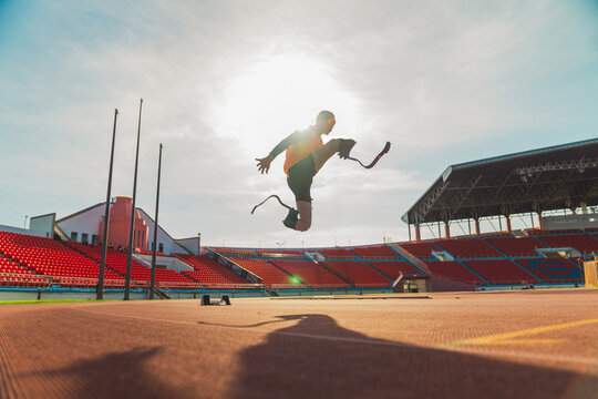 Asian para-athlete runner inspiration prosthetic leg on the track alone outside on a stadium track Paralympic running concept.
