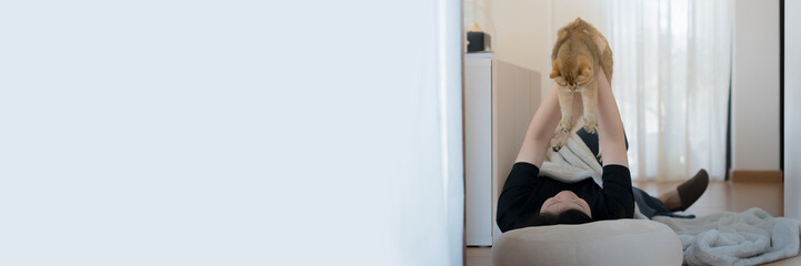 wellness and wellbeing concept with asian woman lie down and read book and play with her cat in livingroom