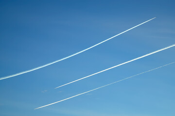 Traces of planes flying towards each other in the sky.