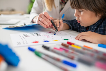 Toddler solving a psychology test with the guidance of a pediatric psychologist