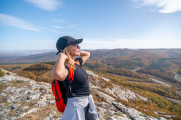 Fototapeta na wymiar woman on mountain peak looking in beautiful mountain valley in autumn. Landscape with sporty young woman, blu sky in fall. Hiking. Nature