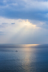 Sunlight pouring through the clouds reflects on the surface of the sea. Morning sunrise scenery on...