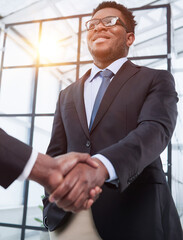 Two business men shaking hands together after successful meeting.