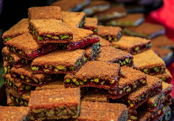 Traditional Turkish dessert, freshly made crispy layered whole nut pistachio pomegranate baklava or ballorieh at a local pastry shop, Istanbul, Turkey
