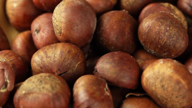 pile of chestnut in wood bowl on wooden table background food rotate footage