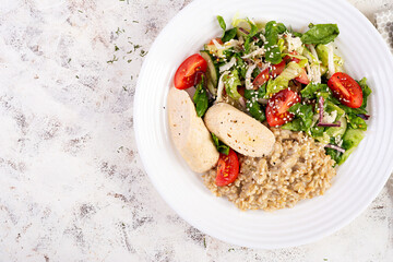 Breakfast oatmeal porridge with boiled homemade chicken sausage and fresh salad. Healthy balanced food. Trendy food. Top view, flat lay