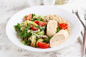 Breakfast oatmeal porridge with boiled homemade chicken sausage and fresh salad. Healthy balanced food. Trendy food.