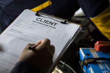 A man holds a clipboard featuring a form with client detail, ready to be filled out.