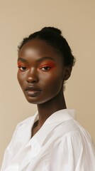 Obraz premium Portrait of a young woman with striking orange eyeshadow and matte lipstick, exuding confidence and modern beauty trends.
