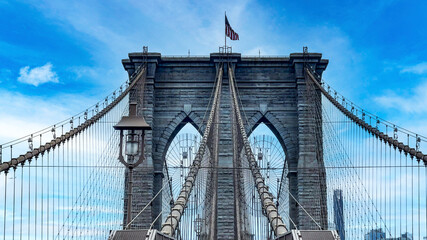The famous and wonderful Brooklyn Bridge linking the boroughs of Manhattan and Brooklyn in New York City (USA), a day with blue sky and lots of clouds.