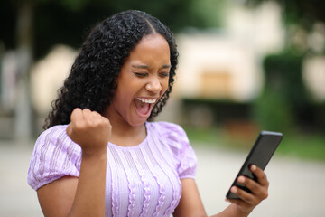 Excited black woman celebrating online news