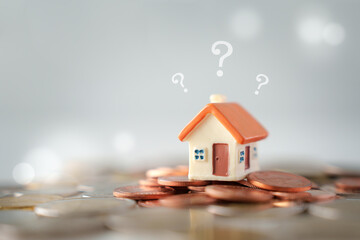 Question mark and house model on coins. Decision to choose the best property. Checklist for...