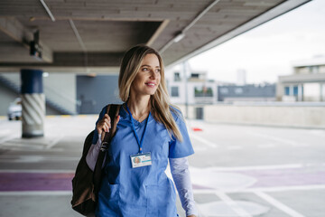 Nurse, doctor walking across hospital parking lot, going home from work. Work-life balance of...