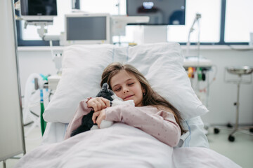 Little girl patient lying in hospital bed. Children in intensive care unit in hospital sleeping.