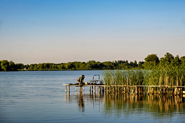 a chair on an old wooden dock in the water on the lake.