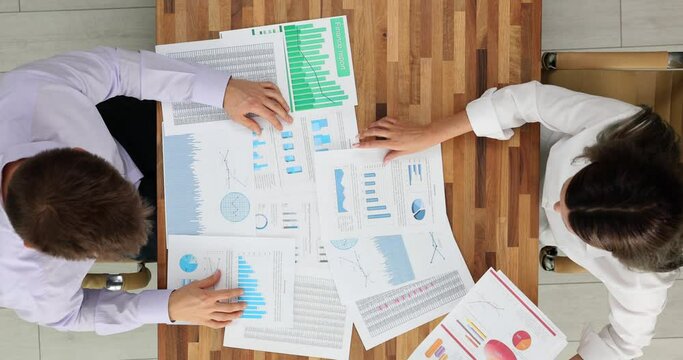 Marketing team works and reviews charts and develops effective strategies top view