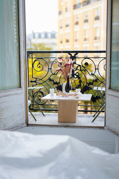 Vase with wine bottle and food on table in balcony