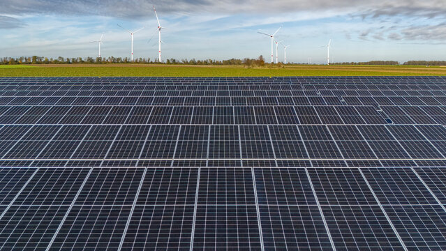 Solar power station with wind farm in background
