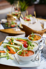 Three dip sauces with vegetables on a plate at brunch table