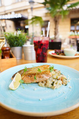 Grilled Salmon with risotto and chanterelle mushrooms on an outdoor table