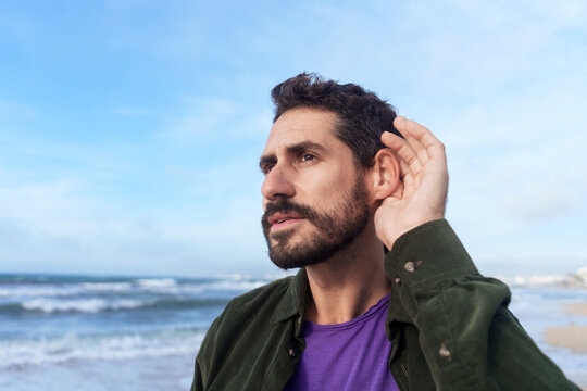 Man eavesdropping near sea at beach