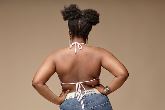 Woman standing with hands on hip against brown background