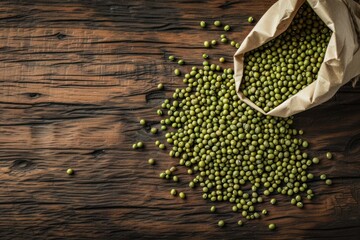 Top view of a Rustic paper bag and a wooden serving scoop full of Mung beans on rustic wooden table. Objects are at right top corner leaving a copy space 