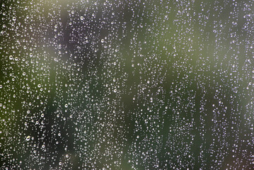 Water droplets on the glass during rain. Texture of water drops on glass.