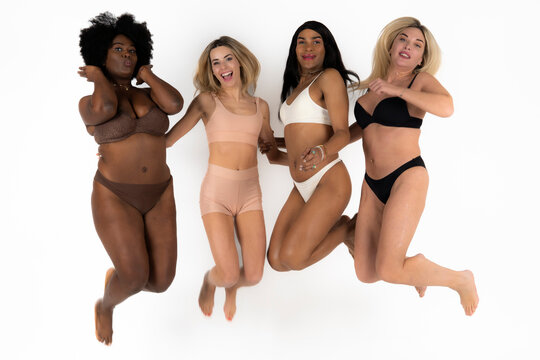 Attractive women and non binary person jumping against white background