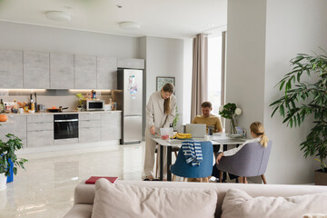 Woman preparing lunch box at table in living room at home